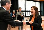 大野委員長（左）から当選証書を受け取る亀井氏＝１日、松江市殿町の島根県庁