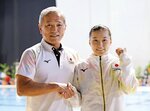 世界選手権の女子３㍍板飛び込みでパリ五輪代表に事実上決まり、安田千万樹コーチ（左）と写真撮影に応じる三上紗也可＝２０２３年７月、福岡県総合プール