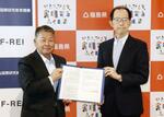 　福島国際研究教育機構と福島ロボットテストフィールドの統合に関する基本合意書を手にする、同機構の山崎光悦理事長（左）と内堀雅雄知事＝１４日午後、南相馬市