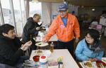 　自主避難所となっている「珠洲市自然休養村センター」で、ボランティアに地元の食材を用いた料理を振る舞う小秀一さん（右から２人目）＝２０２４年３月