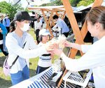 飲食ブースでドリンクを購入する来場者＝２７日、鳥取市東町２丁目の久松公園