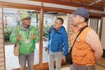 　福井藩の別邸「養浩館庭園」で、島明男さん（右）らをガイドする語り部（左）＝２０２５年４月、福井市