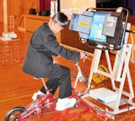 自転車シミュレーターで後方確認をしながら運転する生徒＝１０日、香美町村岡区の村岡中