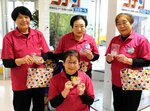 折り鶴を海外観光客に配り草の根交流を続ける「空の駅女子会」のメンバー＝鳥取市湖山町西４丁目の鳥取砂丘コナン空港