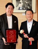 上場通知書を掲げる坂本社長（左）と記念の木づちを持つ平井知事＝２０日、鳥取県庁