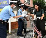 チラシを渡しヘルメット着用などを呼びかける署員＝１４日、鳥取市湖山町南４丁目の鳥取大正門前
