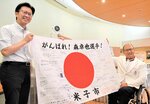 伊木市長（左）から応援メッセージ入りの国旗を受け取る森選手＝３０日、米子市末広町