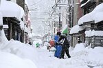 雪が降りしきる中、民家の前の除雪作業に追われる町民ら＝２５日午前９時３７分、智頭町智頭
