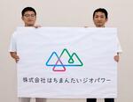 　「はちまんたいジオパワー」のロゴを手にする岩手県八幡平市まちづくり推進課の工藤輝樹さん（右）＝２０２４年８月、同市役所