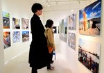 さまざまな猫の写真に魅了される来場者ら