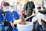 餅つきを体験する利用者（右）