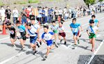 【熱戦火ぶた】　スタートの合図と共に一斉に走り出す男子児童たち。熱戦の火ぶたが切られた