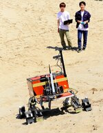 砂地の斜面で地球外探査ローバーの走行を試験するメンバー＝鳥取市浜坂のルナテラス