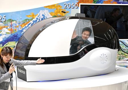 　「大阪ヘルスケアパビリオン」で「ミライ人間洗濯機」を体験する大阪府の吉村洋文知事（右）＝２３日午前、大阪市此花区の夢洲