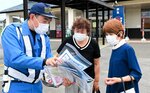 利用者に安全運転を呼びかける隊員（左）