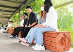 設置したベンチに腰かけ、花の丘を眺める学生ら＝１５日、南部町のとっとり花回廊
