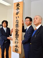 企画実行本部の看板を取り付ける（左から）渡部本部長、伊木市長、鶴田実行委員長＝７日、米子市博労町１丁目