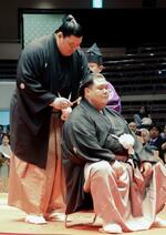 　断髪式で新横綱大の里（左）にはさみを入れられる元小結阿武咲＝１日、両国国技館