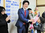 長男・天晴ちゃんから花束を受け取る村上さん＝９日午後１０時３４分、日吉津村今吉の今吉東集会所