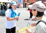 来場者に清掃アイテムを渡して参加を呼びかけるスタッフ（左）＝１７日、ＪＲ米子駅前
