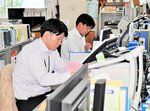 ノーネクタイの軽装で業務に取り組む職員＝７日、新温泉町役場本庁舎