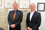 石巻日日新聞社長室で会談した近江社長（右）と吉岡社長。後ろの壁に貼られているのが東日本大震災時に避難所に貼り出された壁新聞