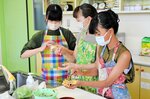 タネを皮で包んで揚げギョーザ作りに挑戦する参加者