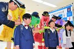 真新しいランドセルにカバーを取り付けてもらう新１年生＝４日、新温泉町戸田の美方署
