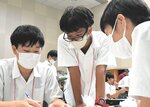 仲間と話し合いながら実技競技に挑む参加者ら＝１９日、鳥取市伏野の鳥取県立福祉人材研修センター