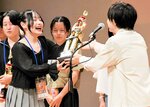 トロフィーを受け取る松下さん＝２４日、鳥取市のとりぎん文化会館