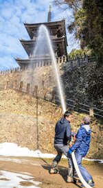 三重塔に向けて放水する団員