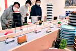 回転ずしのレーンを高速道路に見立てた大型作品＝７日、鳥取県米子市の市美術館