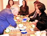 藤井会長（左）にかつての交流事業の写真を見せる李会長。国際定期便の再開を契機に新たな交流のかたちが模索されている＝１０月２６日、春川市内