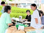 中学生との会話を楽しみながら買い物をする地元住民