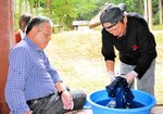 染料に漬けた布を洗い流して発色を確認する参加者＝２１日、香美町小代区広井の古代体験の森