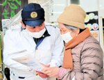 適切な１１０番利用を買い物客に呼びかける署員（左）＝１０日、新温泉町浜坂のスーパー「ナカケー白川店」