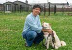 　キドックスのドッグランで保護犬をなでる岡本達也＝２０２４年５月、茨城県つくば市