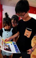 完成した記念号外に見入る来場者＝２７日、湯梨浜町引地の中国庭園燕趙園