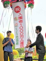 くす玉を割って祝福する佐歩さん（中央）と蒼涼（左）さん＝１９日、南部町のとっとり花回廊