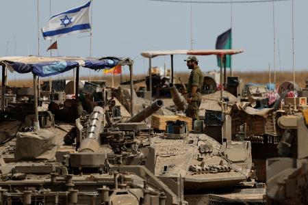 　１７日、イスラエルとパレスチナ自治区ガザとの境界に展開する戦車とイスラエル兵（ロイター＝共同）