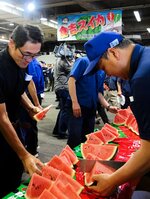 販売セレモニーでスイカを試食する市場関係者ら＝６月７日、大阪市中央卸売市場
