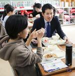 　児童と一緒に給食を食べる中村有希さん（手前右）＝２月、岐阜市