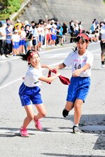 【仲間に託す】　たすきを次のランナーへ。大会には学校統合に伴って来年３月で閉校する佐津、奥佐津小の児童も出場した