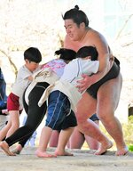 地元出身の滑翔（右）にぶつかっていく児童たち＝１日、新温泉町の浜坂相撲場