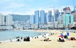 多くの海水浴客でにぎわう松島海水浴場と林立する高層ビル＝２日、釜山広域市西区