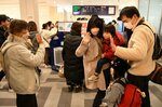 搭乗前に別れのあいさつを交わす家族＝３日、鳥取市の鳥取砂丘コナン空港