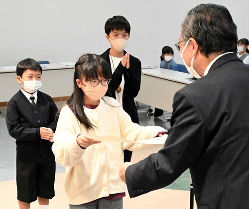 深沢市長（右）から表彰状を受け取る入賞者ら＝２８日、鳥取市富安２丁目の日本海新聞ビル５階ホール