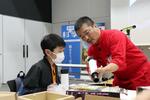 　編集者の説明で天体望遠鏡を組み立てる子ども＝２０２４年１１月、東京都品川区