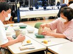 山本さん（左）の指導を受けながら手ろくろ体験に挑戦する参加者