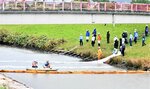 河川への油流出を想定してフェンスを設置する参加者